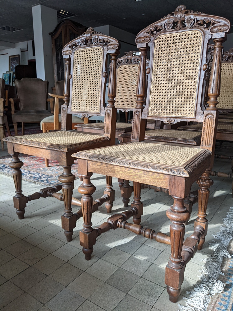 12 oak caned chairs — the caning restored and in good condition
