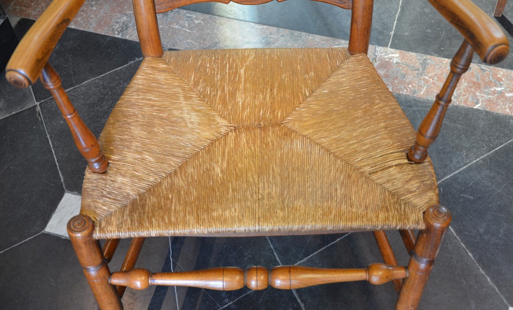 A High back arm chair — The rush seat in need of some repair