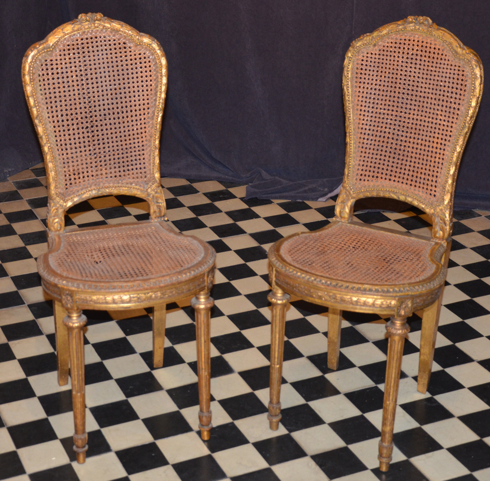 A pair of Napoleon III style carved gilt wood chairs — Paire de chaises en bois doré, de style Napoleon III<br>