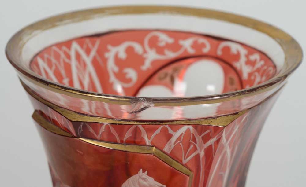 A Bohemian ruby red overlay glass beaker with standing horse, 19th century — Detail of the chips on the rim