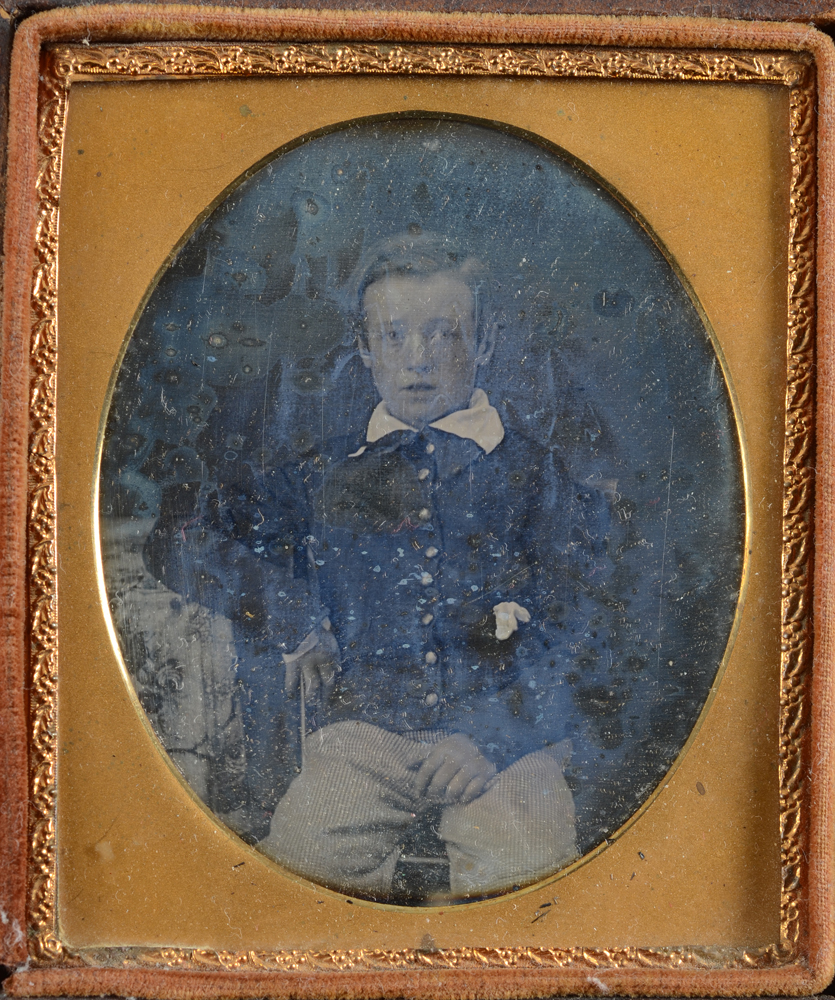 A daguerreotype photograph of a sitting boy — deatil of the photograph, in need of some tlc