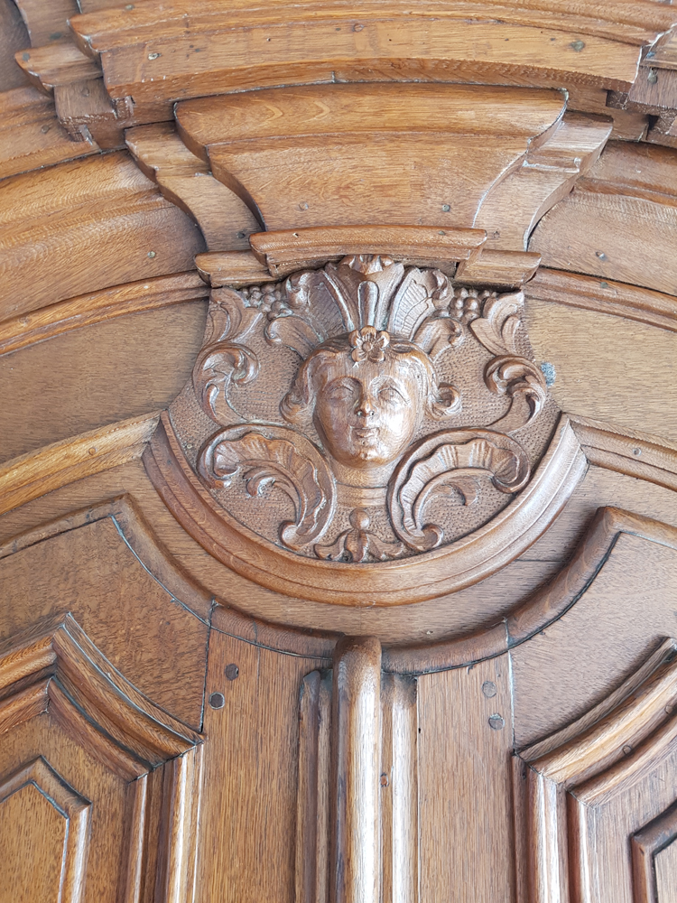 Flemish regence armoire — the central motif above the doors