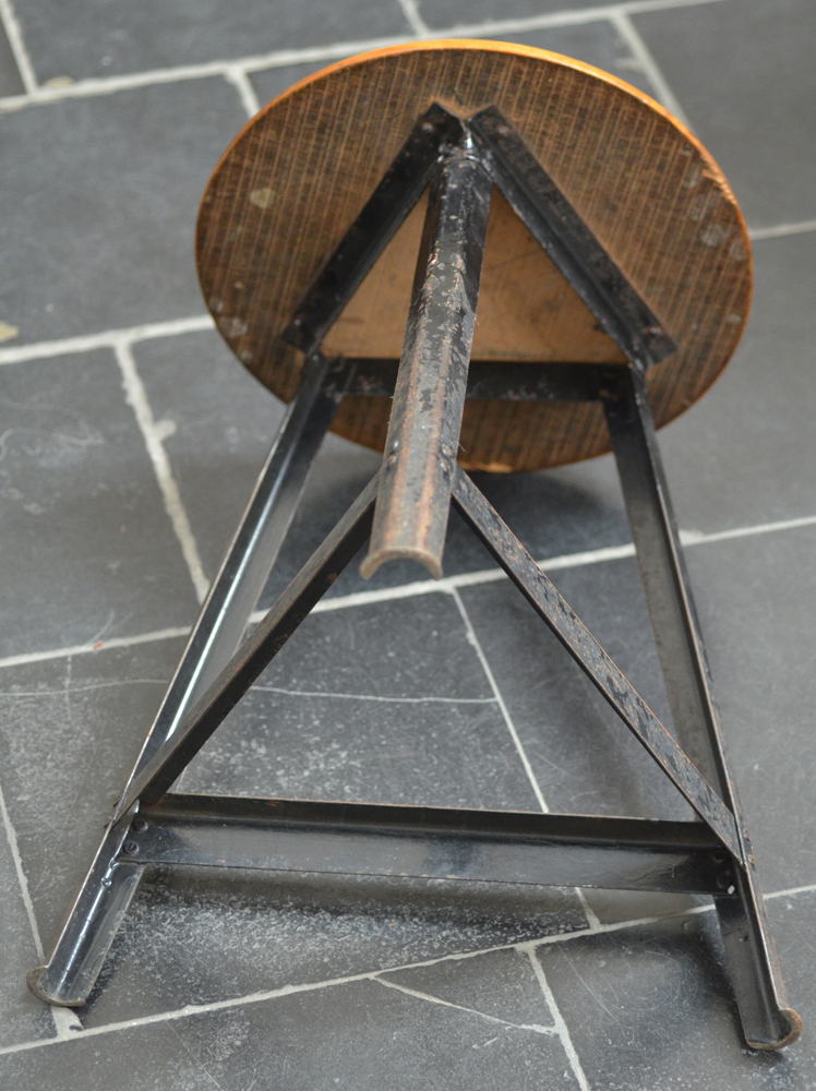 An industrial stool 1950's — view from below, joints at the base rivetted.