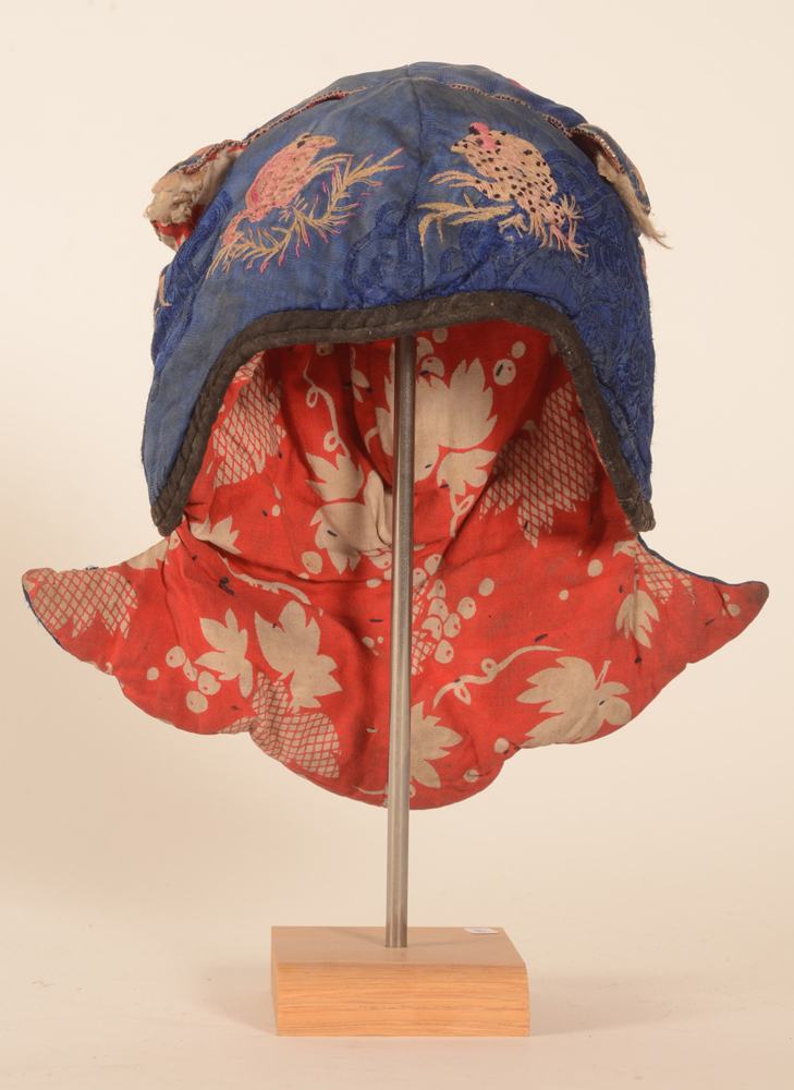 Miao blue silk embroiderednewborn's cap — Frontal view, comes with its stand