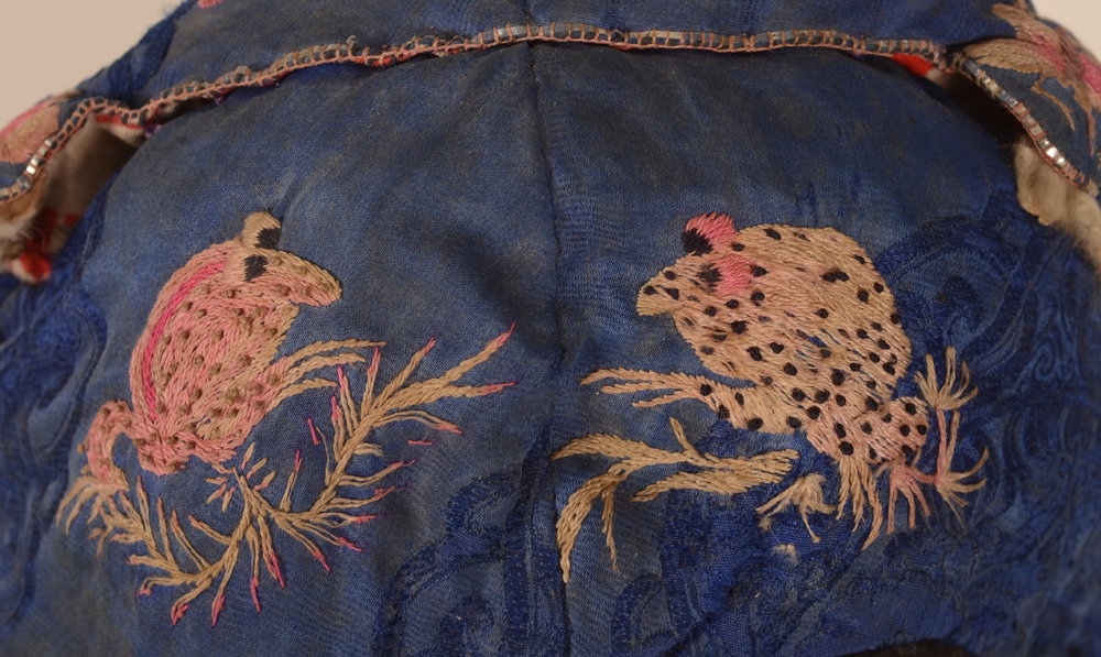 Miao blue silk embroidered newborn's cap — Detail embroidery with frogs, from above&nbsp;
