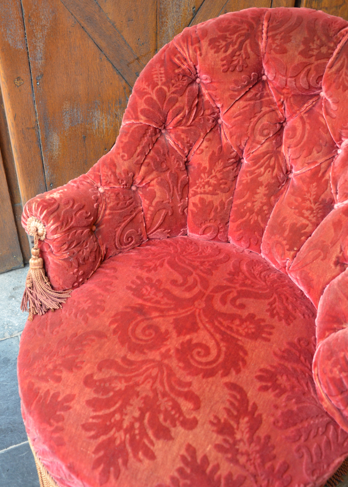 A dramatic red "tassel" Napoleon III crapaud — detail of the slightly worn left armrest
