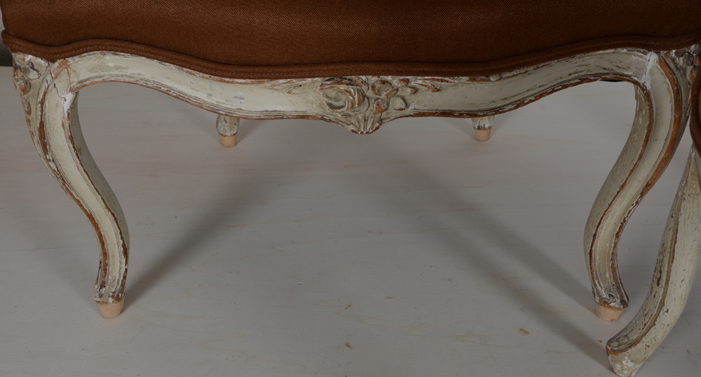 A pair of LXV patinated wood armchairs, possibly from the period — Detail of the carved front, restoration to the legs on this chair visible