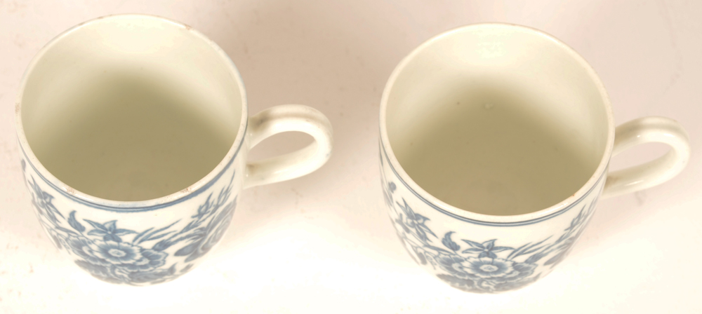 2 18th century Worcester porcelain cups — the three flowers pattern in underglaze transfer printed blue, with delicately shaped handles